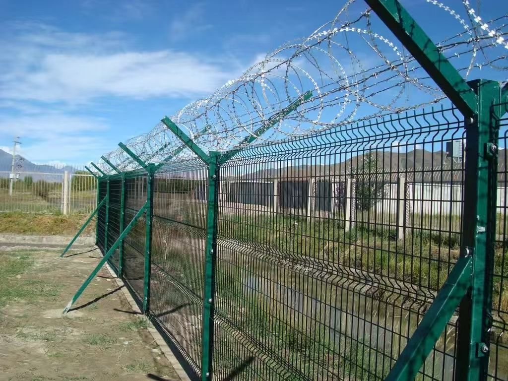 Airport security fence with Y posts and barbed wire topping